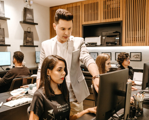 man-teaching-woman-in-front-of-monitor-stockpack-pexels.jpg Man teaching woman in front of monitor