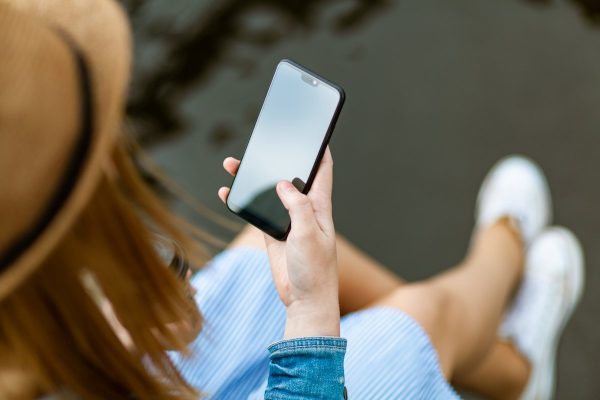Person holding smartphone white sitting