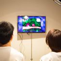 Unrecognizable young couple playing video game at home