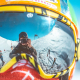 reflection of man holding camera on person's goggles