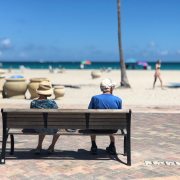 Man and woman sitting on brown wooden bench