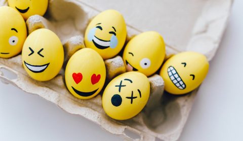 Yellow painted eggs with various facial expressions