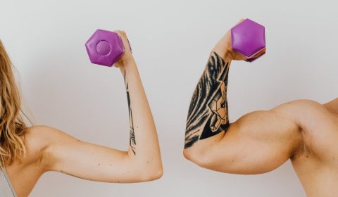 A woman and a man holding dumbbells