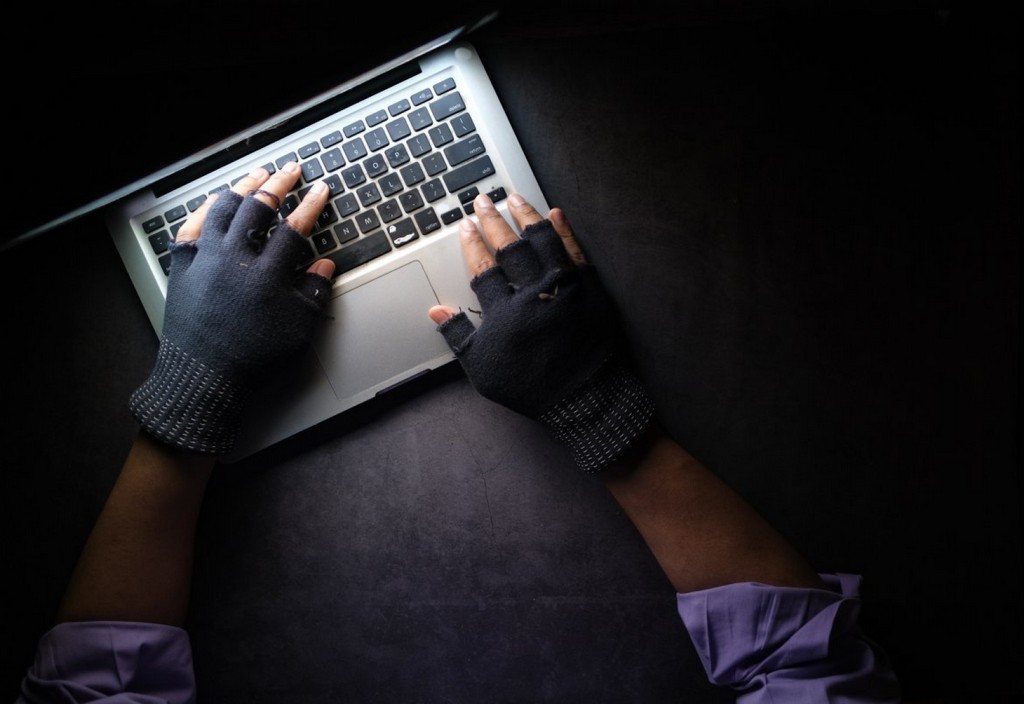 hacker-hand-stealing-data-from-laptop-top-down-stockpack-unsplash.jpg hacker hand stealing data from laptop top down