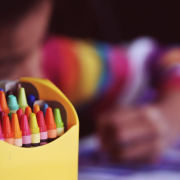 Crayons beside child coloring