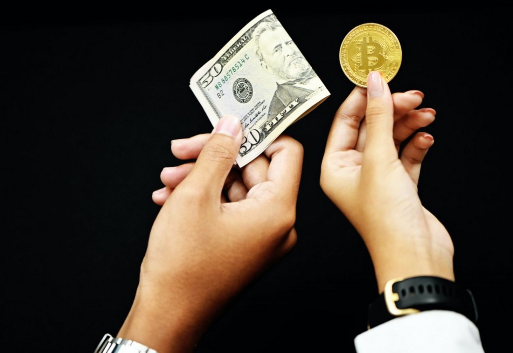 two-people-exchange-money-and-bitcoin-stockpack-unsplash.jpg Two people exchange money and bitcoin