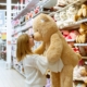 Woman carrying bear plush toy inside store
