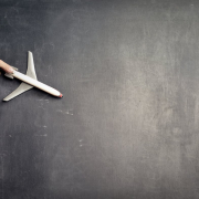 Anonymous person with miniature airplane on chalkboard