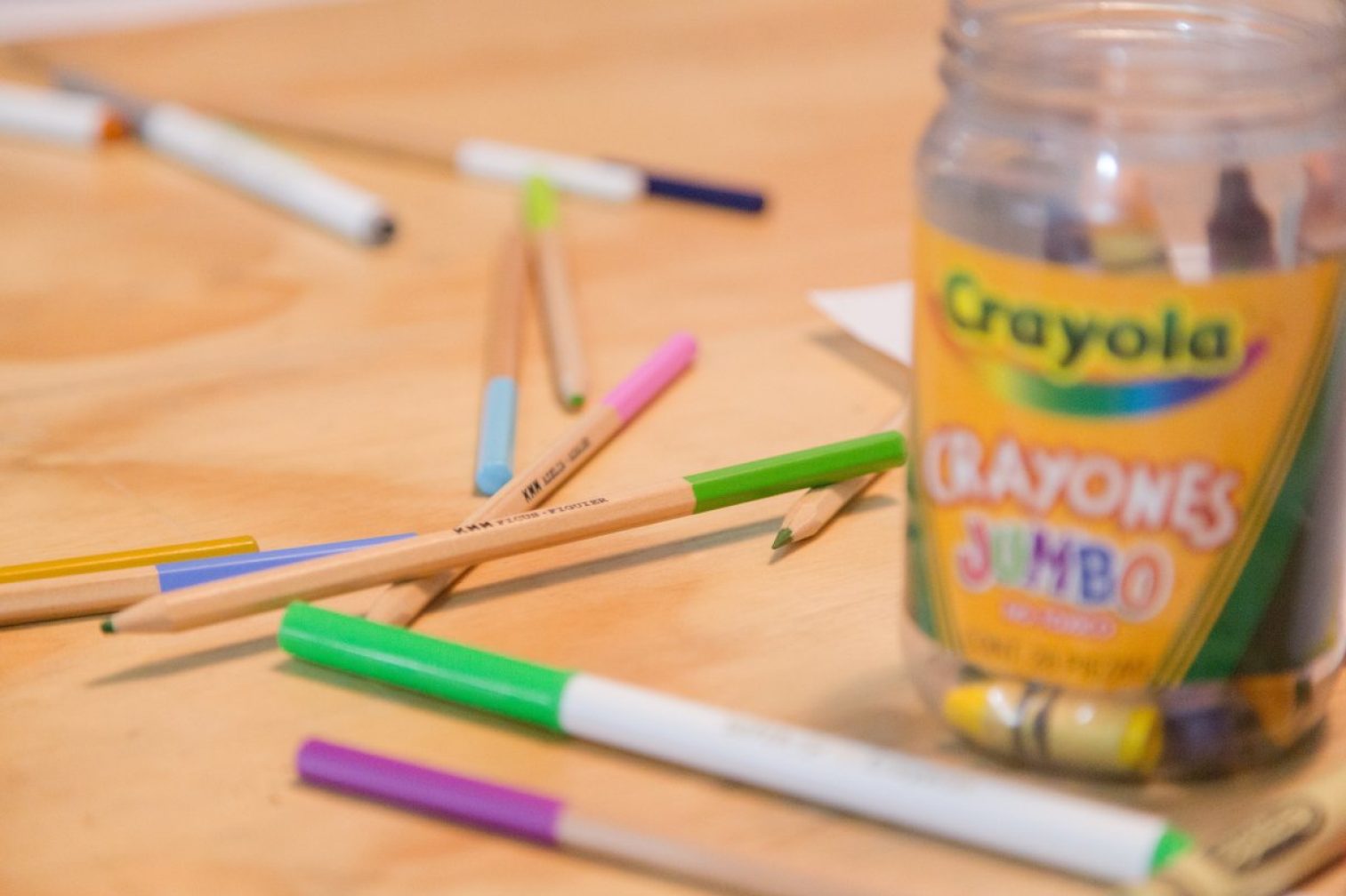 Crayola pencils and crayons scattered on wooden floor