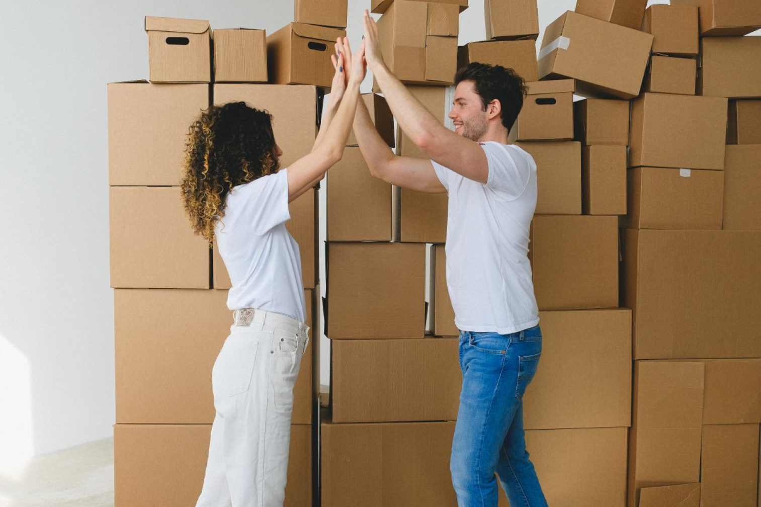 Smiling couple giving high five after moving into new house