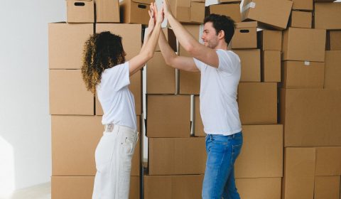 Smiling couple giving high five after moving into new house