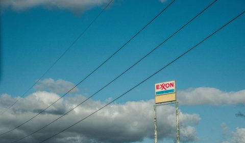 Old exxon sign in the sky, with wires sweeping the shot.