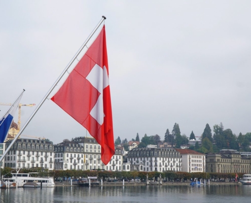 red and white flag on pole near body of water during daytime