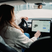 woman in white sweater driving car