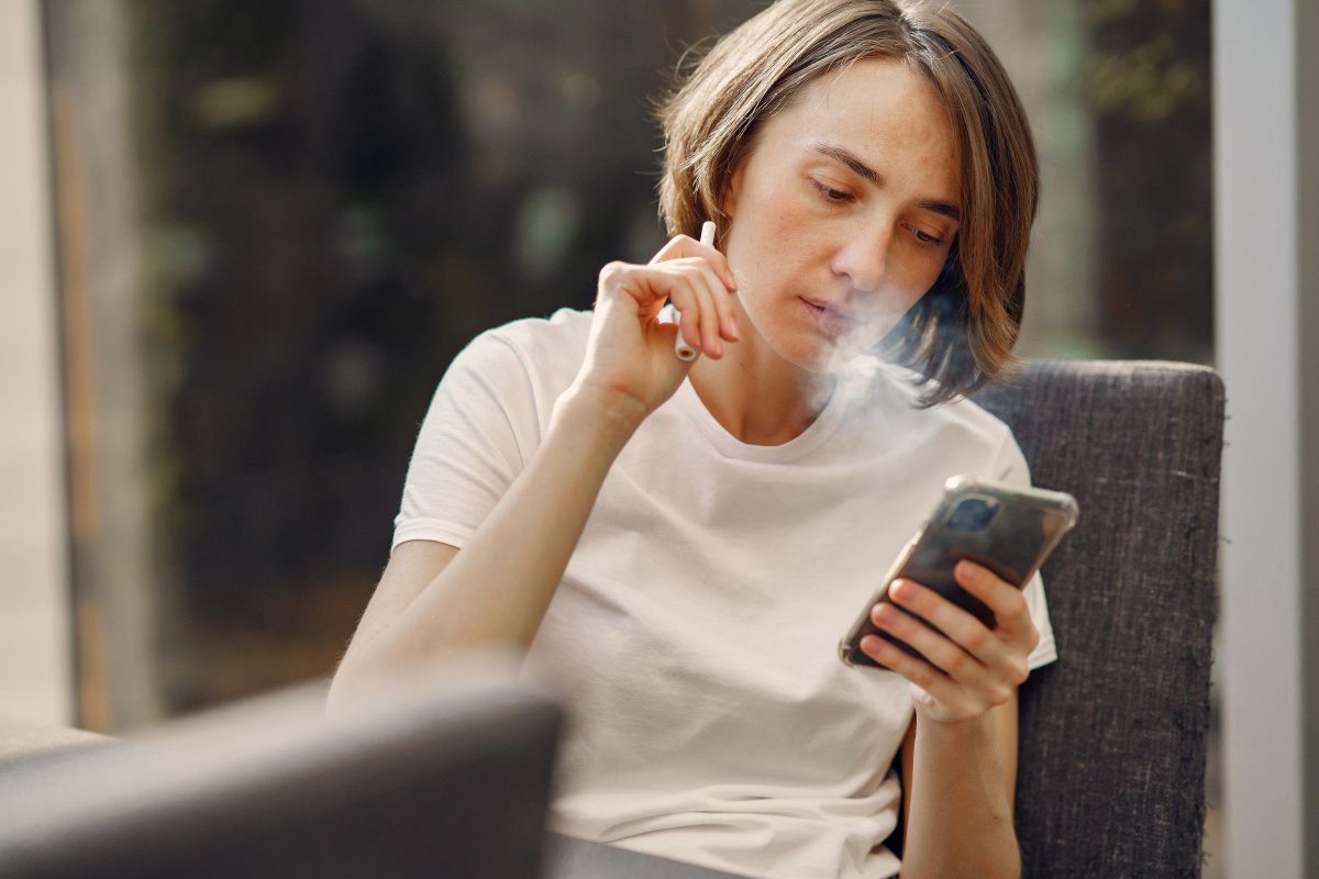woman-smoking-while-holding-her-phone-stockpack-pexels.jpg Woman smoking while holding her phone