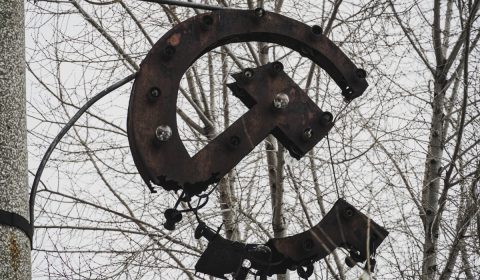 a large metal sign hanging from the side of a tree