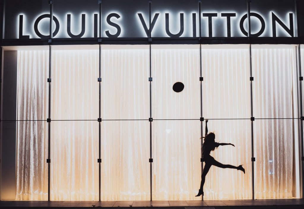 a-woman-jumping-beside-glass-wall-with-louis-vuitton-signage-stockpack-pexels.jpg A woman jumping beside glass wall with louis vuitton signage