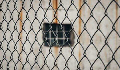 black and white square device on brown metal fence