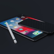 Black iPhone on top of Black iPad with an Apple Pencil