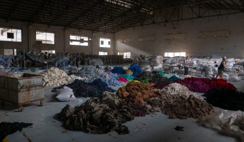 Sorting through hundreds of tons of clothing in an abandoned factory for a social mission called Clothing the Loop.