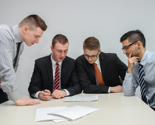 four-men-looking-to-the-paper-on-table-stockpack-unsplash.jpg four men looking to the paper on table