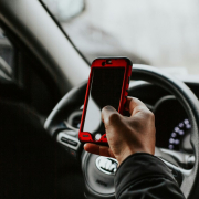 person-holding-red-smartphone-sitting-in-front-of-vehicle-steering-wheel-stockpack-unsplash.jpg person holding red smartphone sitting in front of vehicle steering wheel
