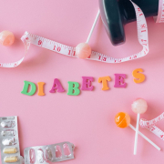 Lollipops meter and medicaments on a pink background around letters creating a word diabetes