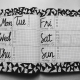 White and black weekly planner on gray surface