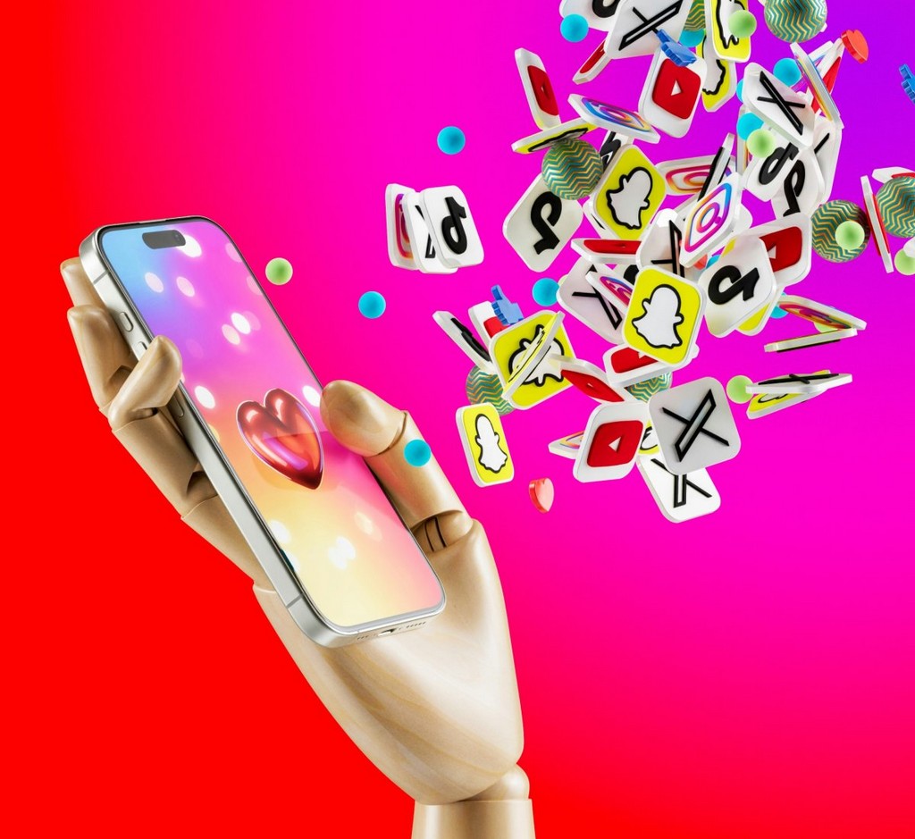 Wood hand holding an iPhone 15 Pro with an explosion of likes, thumb ups and apps