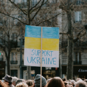Large group of people holding banner on supporting ukraine