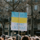 Large group of people holding banner on supporting ukraine