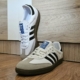 a pair of white and black shoes on a wooden floor