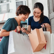 Happy asian women showing purchases to each other