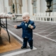A young boy in blue suit smiling