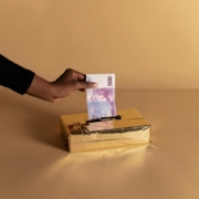 person-putting-money-inside-the-gold-box-stockpack-pexels.jpg Person putting money inside the gold box