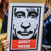 a person holding a sign with a picture of a man's face on it