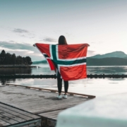 woman-with-norway-flag-stands-on-dock-stockpack-unsplash.jpg Woman with Norway flag stands on dock.