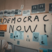woman-looking-at-wall-with-democracy-now-text-written-in-it-stockpack-unsplash.jpg
