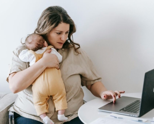 young-working-mother-cuddling-baby-and-using-laptop-at-home-stockpack-pexels.jpg Young working mother cuddling baby and using laptop at home