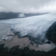 Majestic glacier tongue reaching seashore under gloomy misty sky
