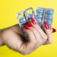 a-womans-hand-holding-two-contraptions-in-front-of-a-yellow-background-stockpack-unsplash.jpg