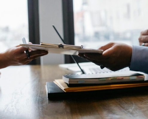 Crop black job candidate passing resume to hr employee