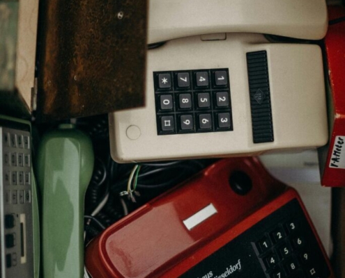 Black and white ip desk phone beside brown leather wallet