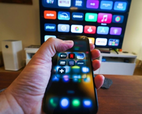 Hand holding smartphone with streaming apps