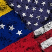 Concept of a Conflict between the United States of America and Venezuela with painted flags on a wall with a crack