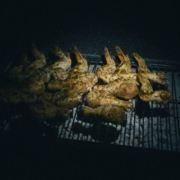 Grilled chicken wings on barbecue at night