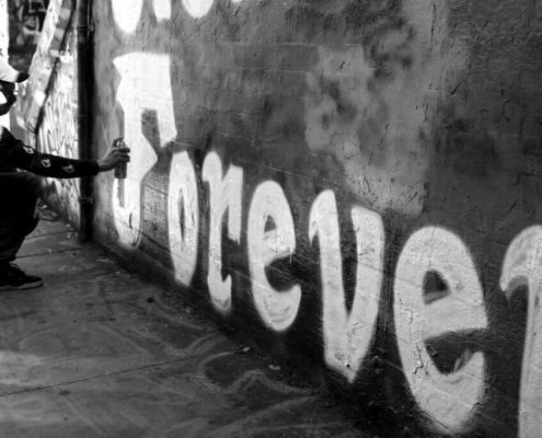 a-person-sprays-forever-graffiti-on-a-wall-stockpack-unsplash.jpg
