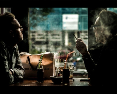 Two men in a coffee shop smoking