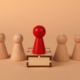 Red leader pawn surrounded by wood pieces