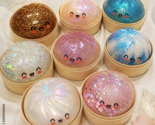 collection-of-eight-cute-kawaii-glitter-dumpling-toys-with-smiley-faces-in-various-sparkle-colors-displayed-in-bamboo-steamer-boxes-stockpack-adobe-stock.jpg collection of eight cute kawaii glitter dumpling toys with smiley faces in various sparkle colors displayed in bamboo steamer boxes